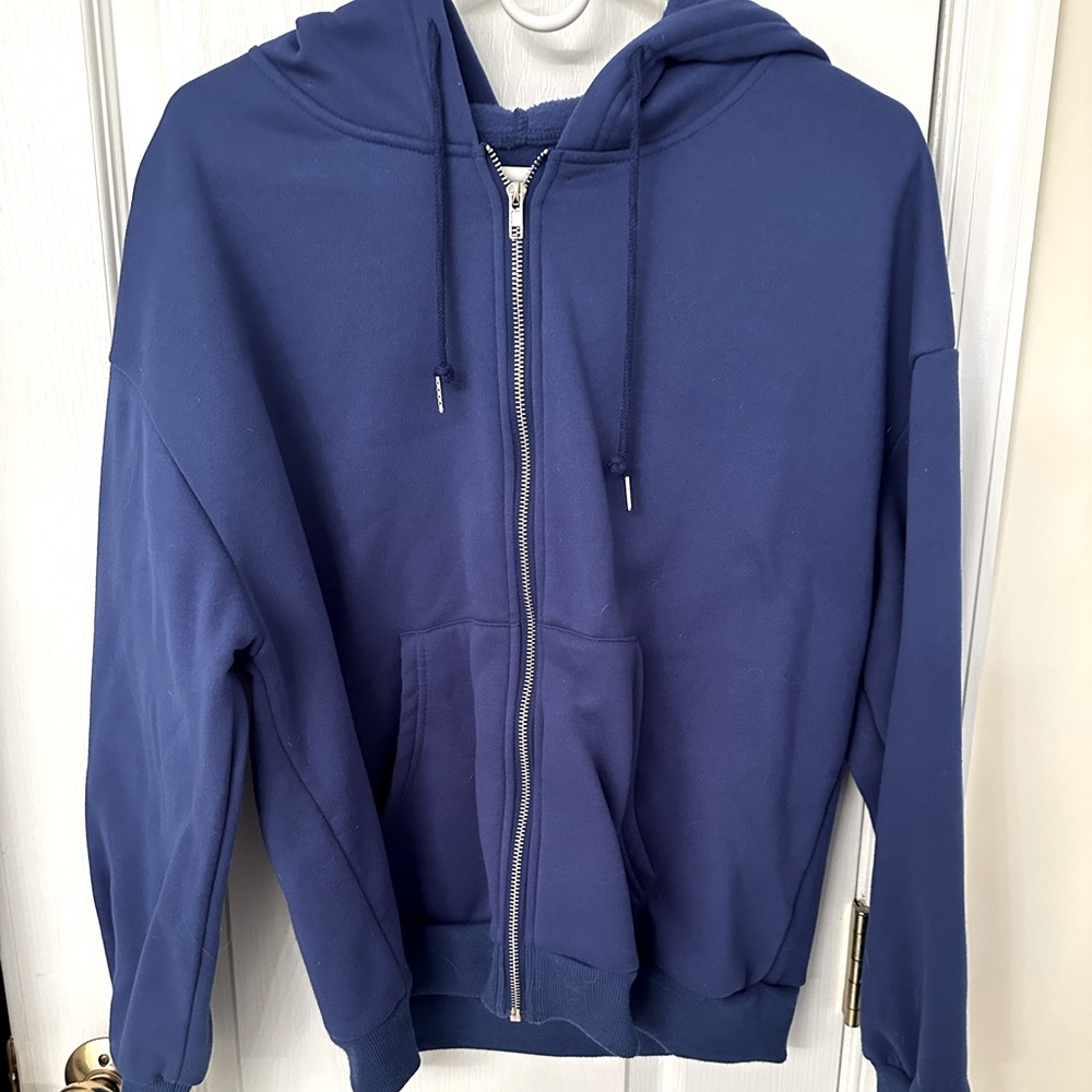 Blue zip up hoodie, slightly oversized. Not too thick but super cozy